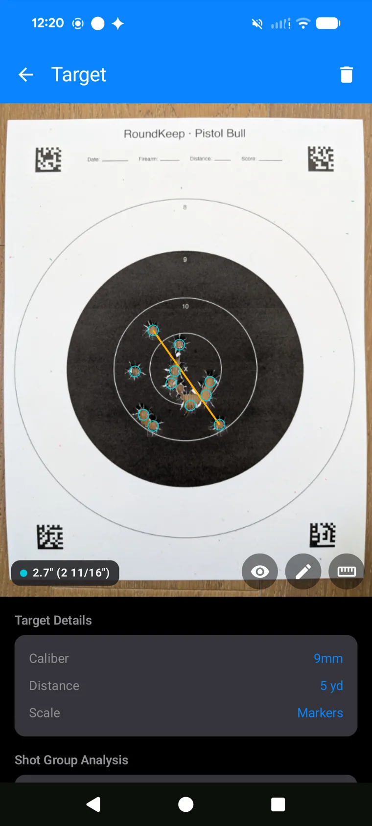 RoundKeep Zero measuring a 10-shot group on a printed Pistol Bull target — 2.7 inch extreme spread