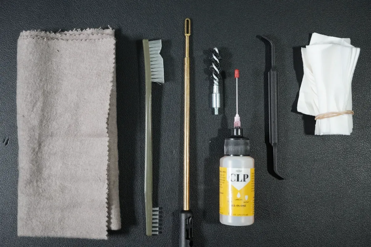 Basic firearm cleaning supplies: rag, brushes, cleaning rod, bore brush, CLP, pick, and patches